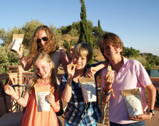 Ein gruppe von Kindern isst getrocknete Mangos aus Spanien
